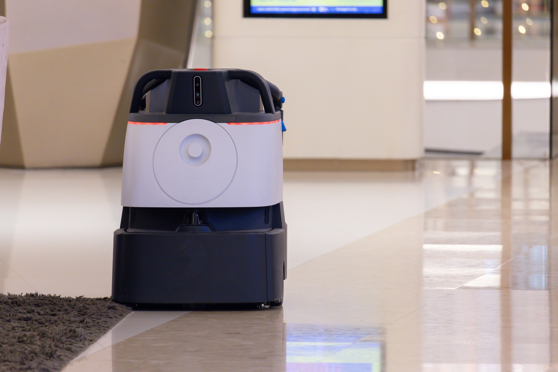 Un aspirateur robot est posé sur le sol d’une pièce