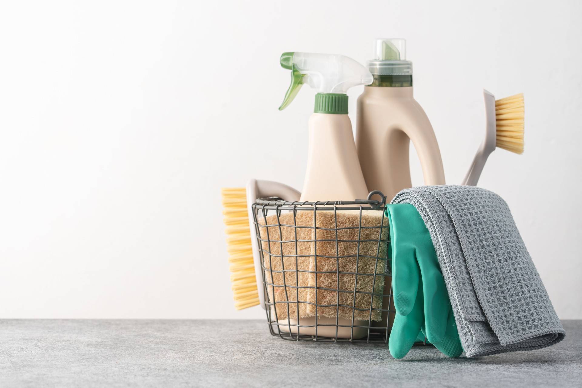 Brosses, éponges, gants en caoutchouc et produits de nettoyage naturels dans le panier